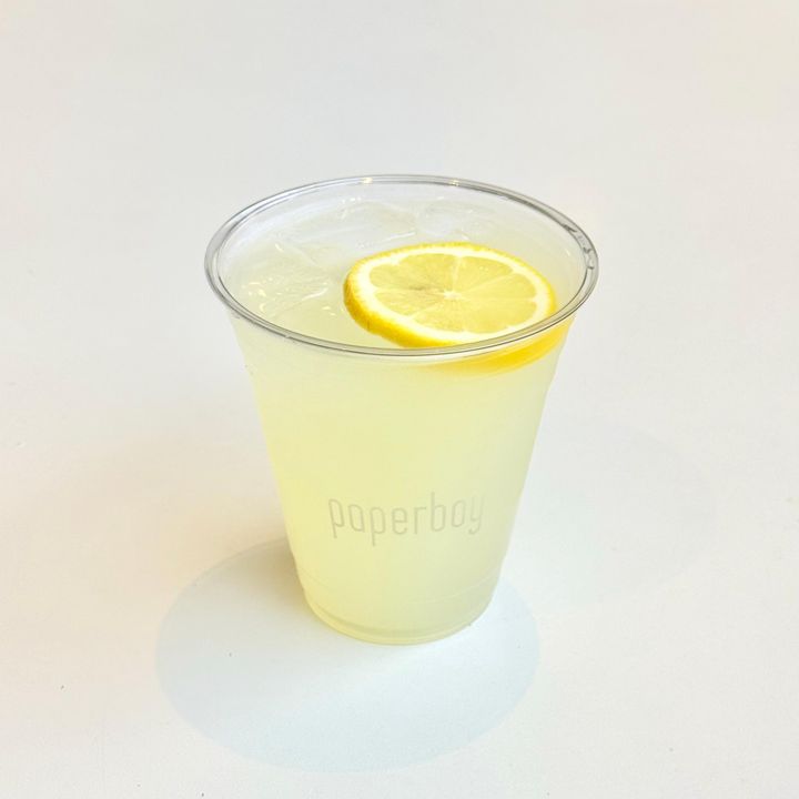 A glass bottle of lemonade with a paper label