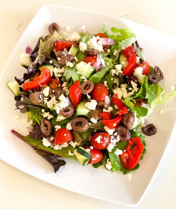 A photo of a Greek Salad with tomatoes, cucumbers, and feta cheese