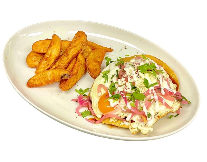 A plate of Huevos Rancheros with a fried egg, tortillas, and cheese.