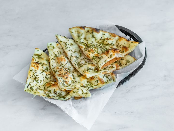 Photo of Garlic Naan on a wooden cutting board